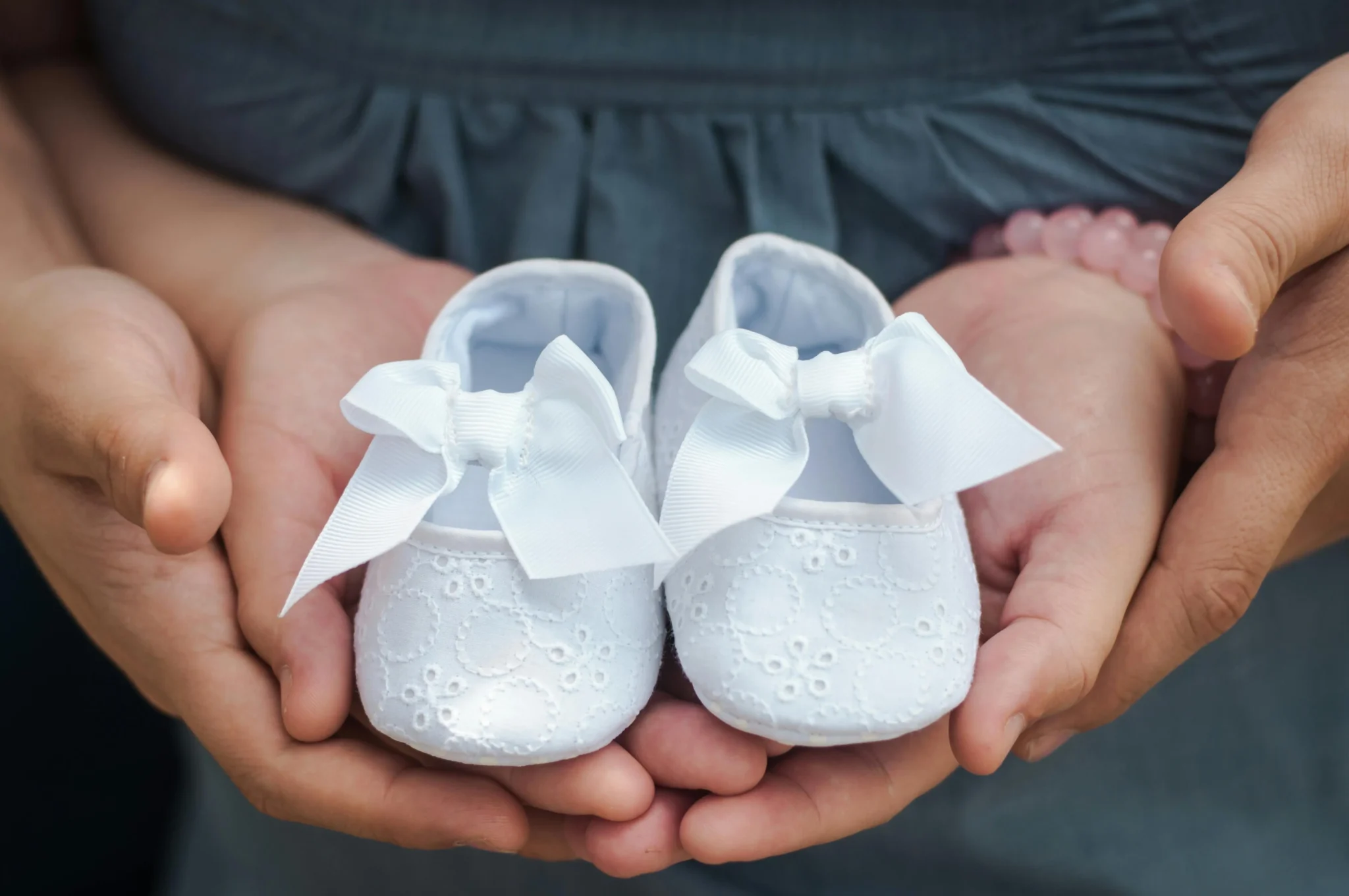 woman holding baby shoes