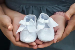 woman holding baby shoes